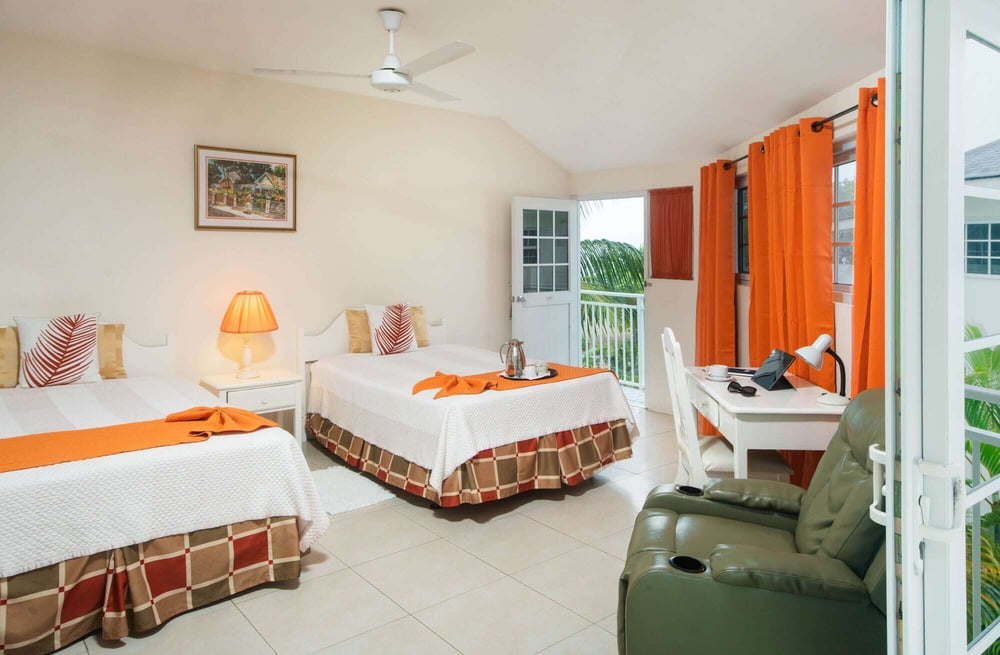 Beachfront room in Negril with two double beds, rain shower, minibar, in-room safe, and balcony.